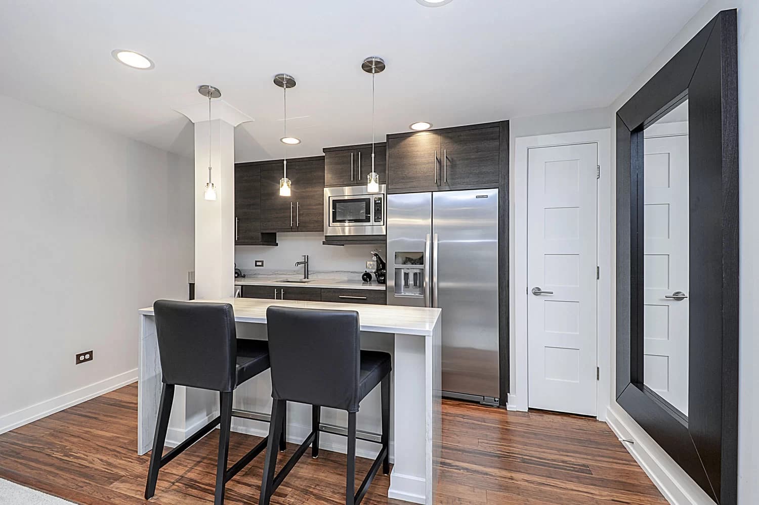 Open-concept finished basement with recreation area and kitchenette