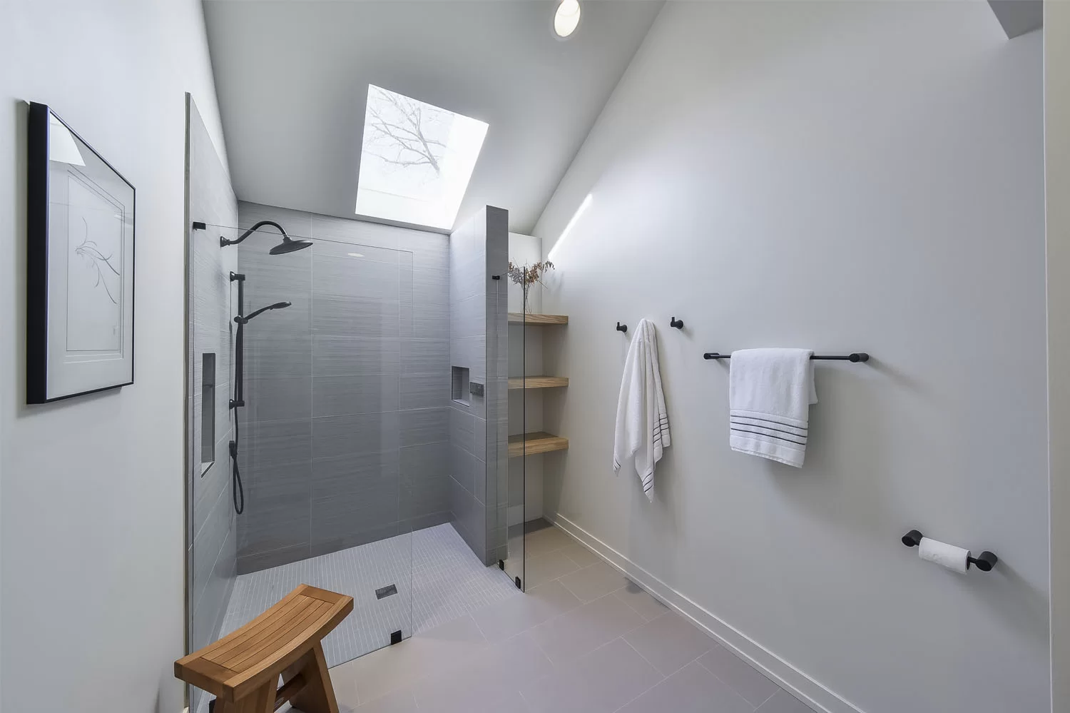 Luxury bathroom renovation with rain shower and built-in storage niches