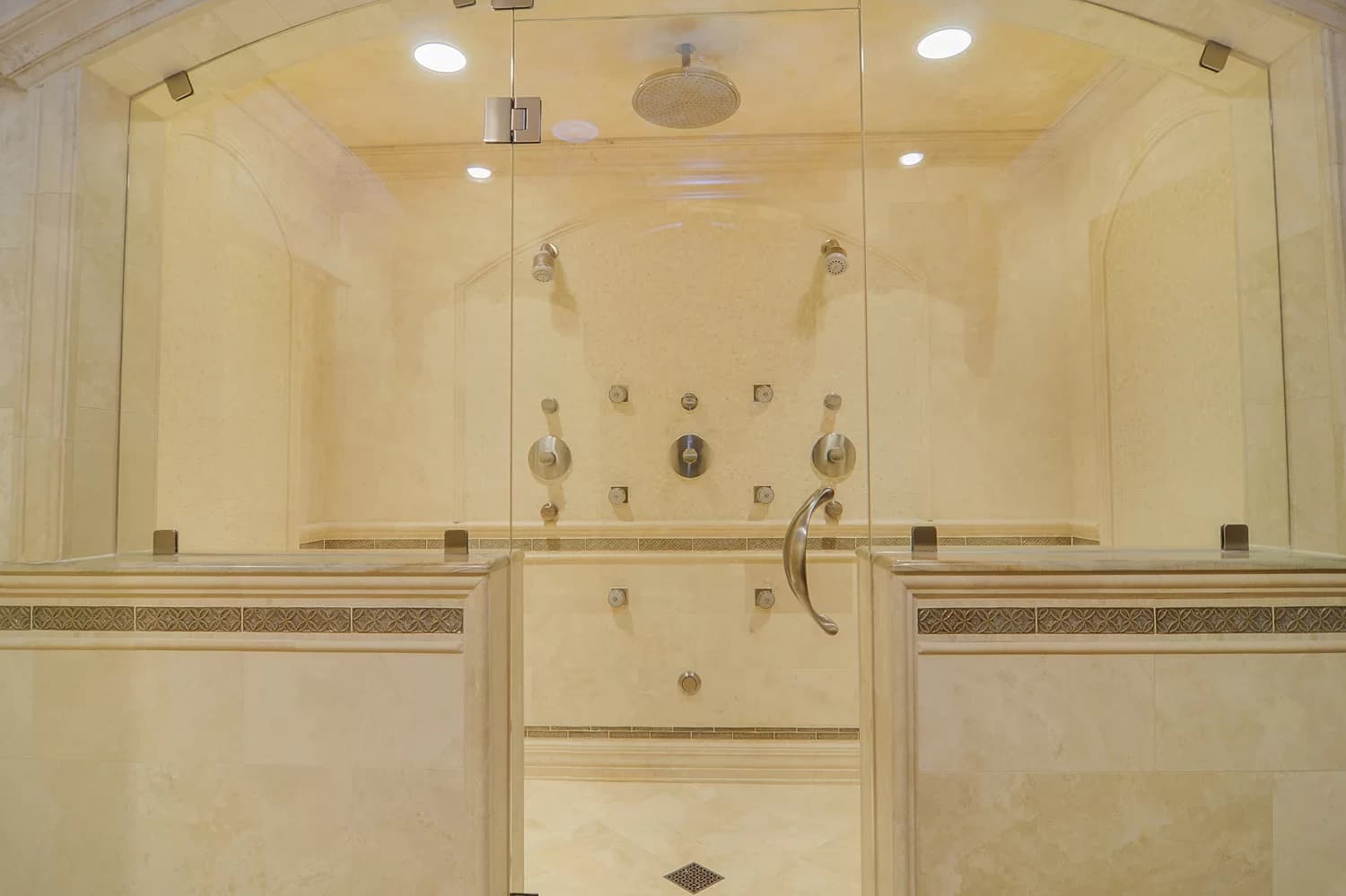 Modern walk-in shower with frameless glass enclosure and marble tile in Seattle bathroom remodel